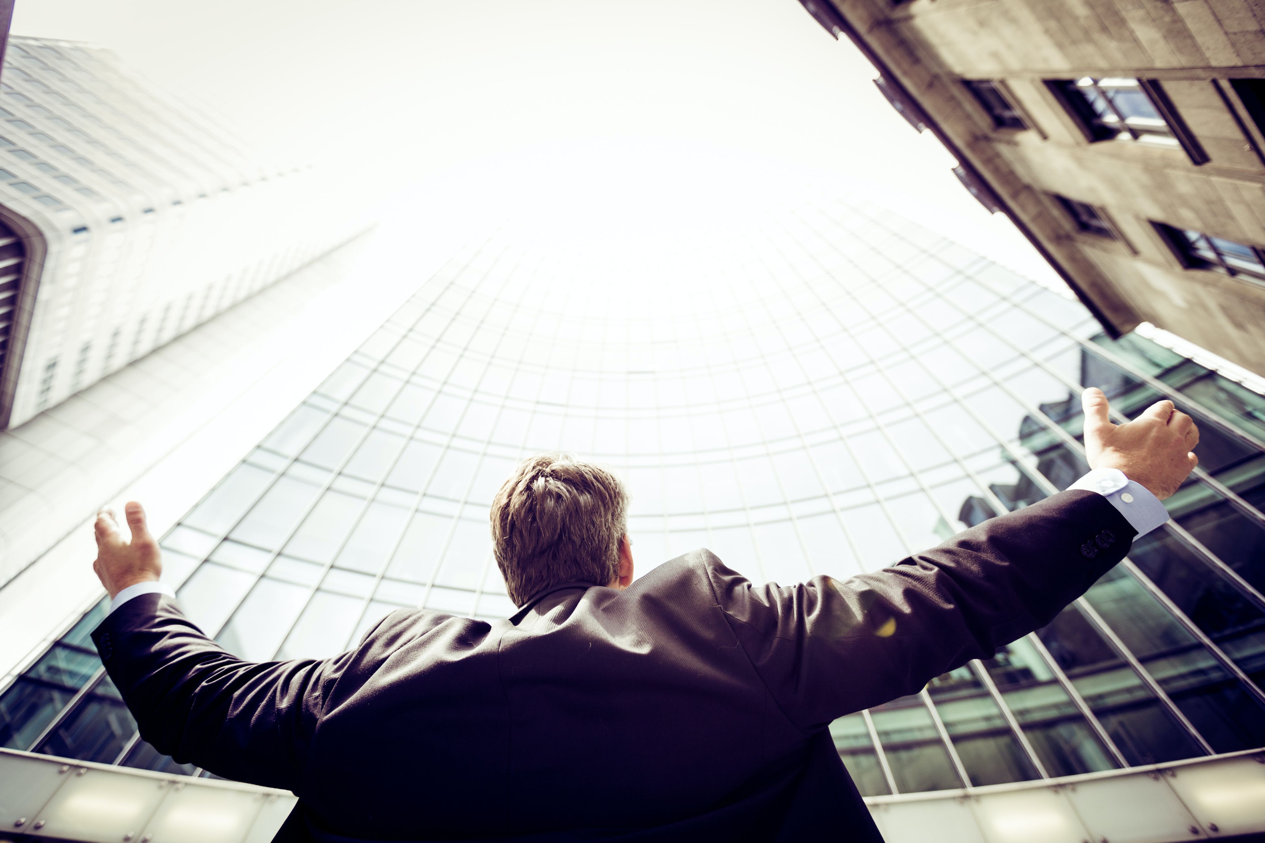 low-angle photography of man in the middle of buidligns